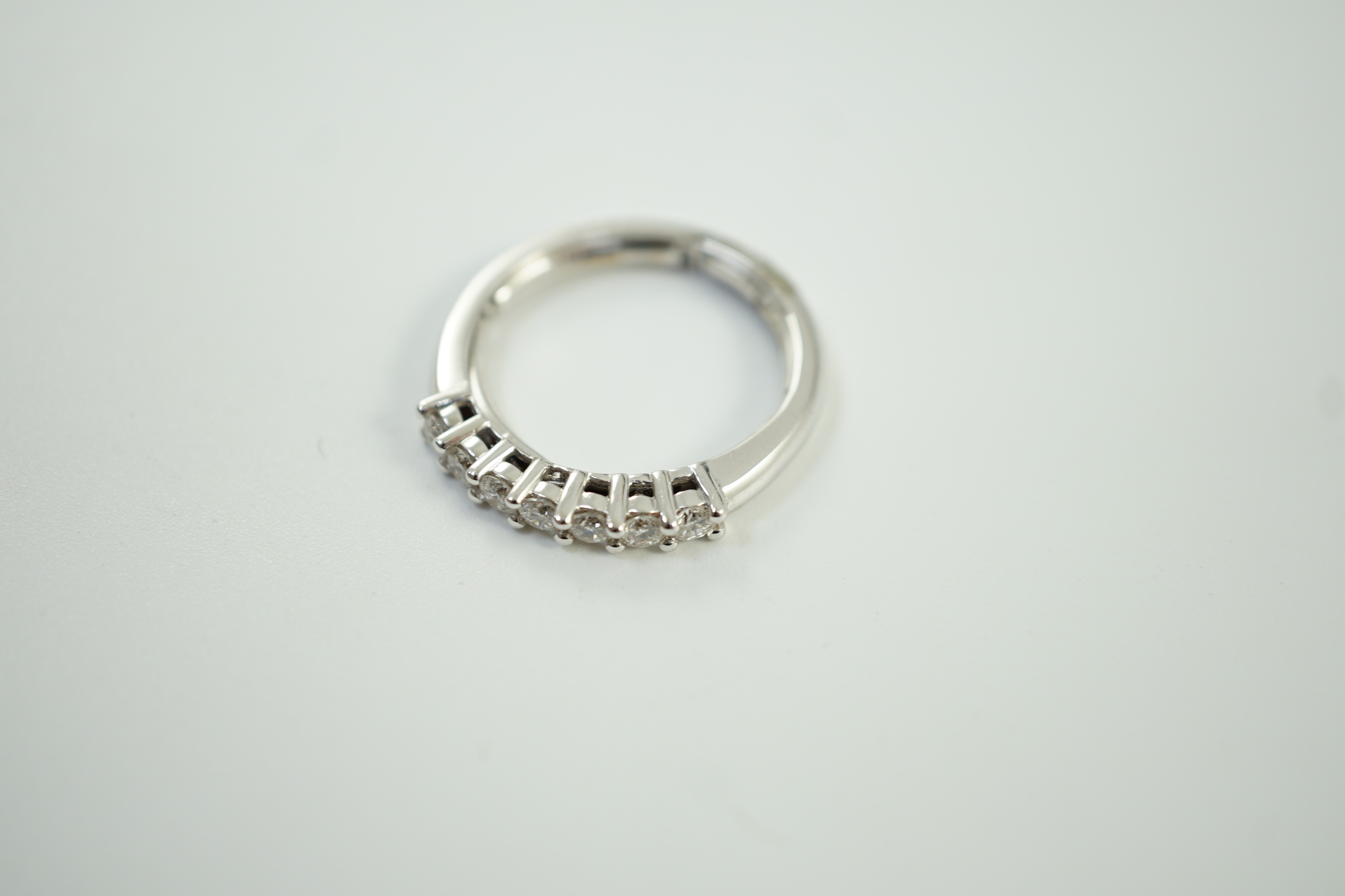 A modern Italian 18ct white gold and seven stone diamond set half hoop ring, size N, gross weight 3.9 grams.